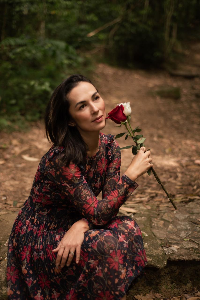 Aline Hayashi segurando rosas em meio à natureza